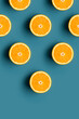 Minimal pattern of oranges fruit with pyramid shape at blue background.