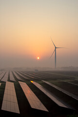 Wind power and solar power plants at sunrise and sunset