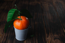 Fresh Tangerines With Leaves In A Bucket On A Wooden Old Background