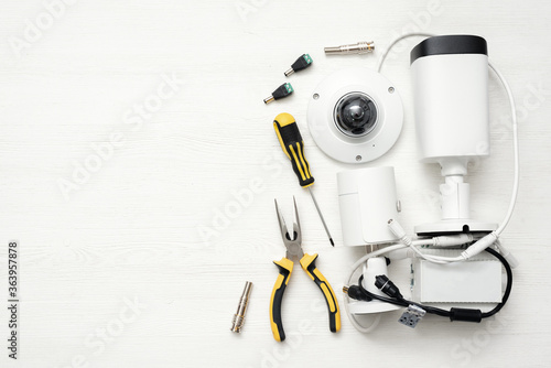 Fotografía Modern white security cameras and work tools on the table background