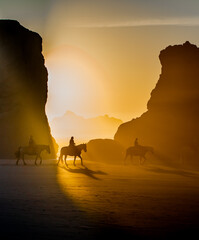 Wall Mural - Horseback riders on the beach at Bandon, on the southern Oregon coast,  at sunset