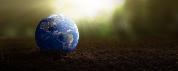 planet earth on soil for plants - environmental care concept - elements of this image furnished by n