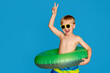 © Юлия Призова - Happy cute baby boy 6-7 years old in sunglasses and with a life buoy. Summer and the sea.