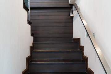 Wall Mural - Modern minimalist style stairs with brown wooden and steel handrails.