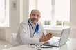 © Studio Romantic - Practicing doctor senier sitting at a table with a laptop at the workplace in the office of the clinic.