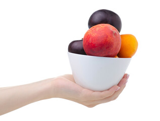 Canvas Print - Hand holding bowl with fruit apricots, plums, peaches on white background isolation