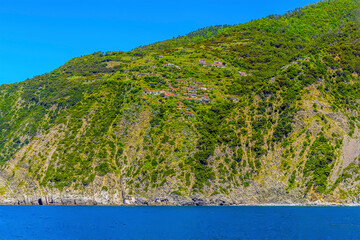 A view of cliff top villages perched on the cliffs of the Cinque Terre coast near to Porto Venere, Italy in the summertime