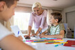 © pikselstock - Mother helping her kids doing homework at home