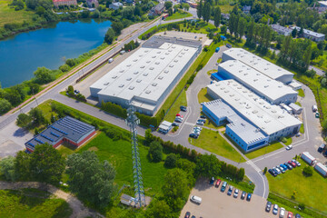 Aerial view of goods warehouse. Logistics center in industrial city zone from above. Aerial view of trucks loading at logistic center