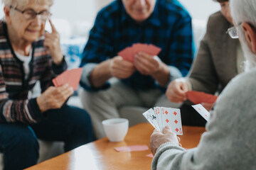 Wall Mural - Senior friends sit at a coffee table and play cards