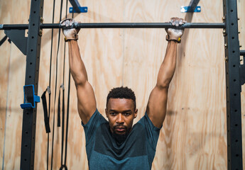 Athletic man doing pull up exercise at the gym.