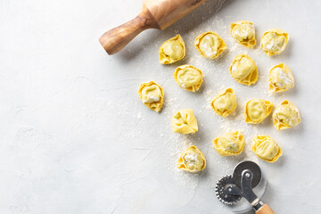 Raw ravioli on a light grey background. Top view.