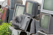 old dirty broken electronics dump overgrown with grass