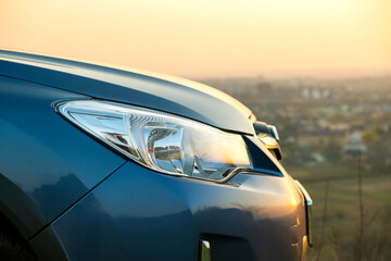 Canvas Print - Close up detail of front headlight lamp of modern car at sunset.