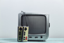 Old Tv Receiver With Retro Joysticks On A White Wall Background. Retro Gaming. 80s