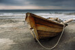 © alefat - Old fishing wooden boat on the shore.