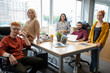 © pressmaster - Group of intercultural business people in casualwear gathered by large table