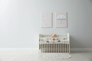 Poster - Minimalist room interior with baby crib, decor elements and toys. Space for text