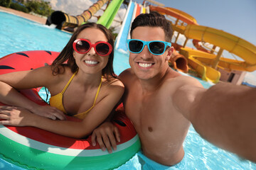 Wall Mural - Happy couple taking selfie at water park. Summer vacation