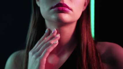 Wall Mural - Colored light model. Beauty wellness. Woman touching neck skin gently in pink neon glow.