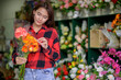 © PK Studio - young woman small business florist arranging plants in flower shop