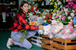 © PK Studio - young woman small business florist arranging plants in flower shop
