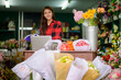 © PK Studio - young woman small business florist arranging plants in flower shop