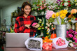 © PK Studio - young woman small business florist arranging plants in flower shop