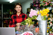 © PK Studio - young woman small business florist arranging plants in flower shop