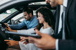 © Dusko - Middle age couple choosing and buying car at car showroom. Car salesman helps them to make right decision.