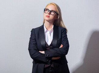 Poster - Beautiful blonde businesswoman in suit on gray background