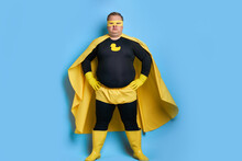 Cleaning Superhero Saves The World From Dirt, Man Has Duck Picture On Costume, He Is In Yellow Wear And In Protective Gloves, Posing Isolated Over Blue Background