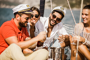 Wall Mural - Smiling friends with glasses of champagne on yacht. Vacation, travel, sea, friendship and people concept