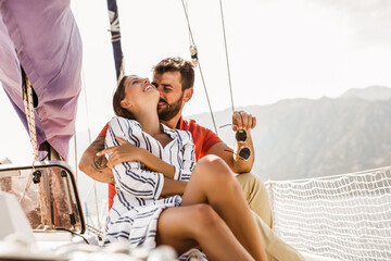 Wall Mural - Loving couple spending happy time on a yacht at sea. Luxury vacation on a seaboat.