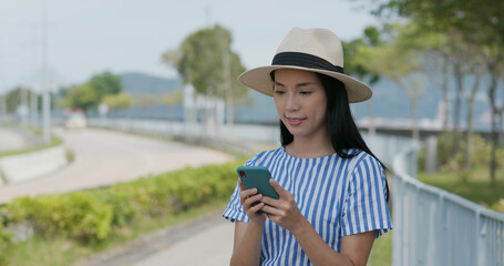 Poster - Woman search on cellphone of the location in city