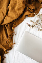 Wall Mural - Minimal flat lay, top view lifestyle composition with laptop, eucalyptus branch, ginger plaid on white linen.