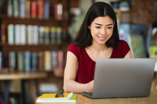Online Education. Smiling Asian Girl Studying With Laptop While Sitting At Cafe