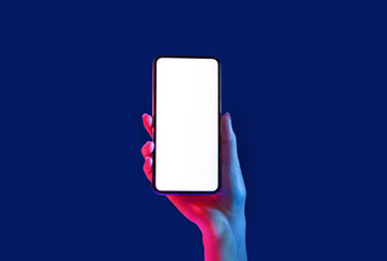 Smartphone in neon. Woman hand holds phone, isolated on blue background