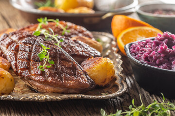 Fresh grilled duck breasts served with roasted potatoes and red cabbage