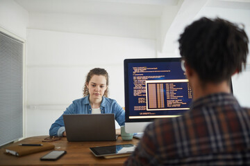 Wall Mural - back view portrait of african-american man writing code on computer screen while working at desk in 