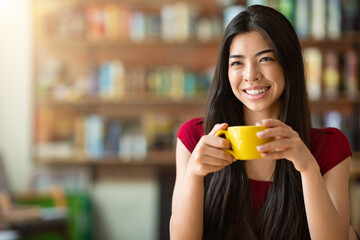 Time For Coffee. Happy asian woman enjoying cup of cappuccino in cafe