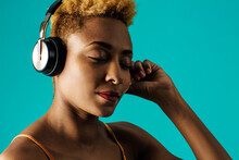 Close Up Portrait Of A Young  Woman With Headphones Listening To Music With Eyes Closed