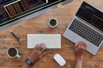 Wall Mural - top down view at male hands typing on keyboard at contemporary workplace with computers and coffee c