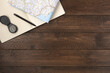 © Konstantin Maslak - Map and open notebook isolated, on wooden background. Flat lay, top view, copy space.