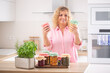 © weyo - Woman looking at fresh home-made preserves in her hands with more pickles in jars in front of her