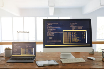 Front view background image of two computers with programming code on screen in minimal home office interior with wooden accents, copy space