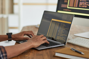 Wall Mural - close up of african-american computer programmer typing on keyboard with black and orange programmin