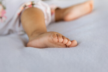 Wall Mural - Adorable baby feet on pastel background in a selective focus