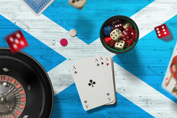 Wall Mural - Scotland casino theme. Aces in poker game, cards and chips on red table with national flag background. Gambling and betting.