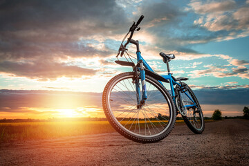 Wall Mural - Bike on a sunset background. The concept of a healthy lifestyle, sports training, cardio load. Copy space.